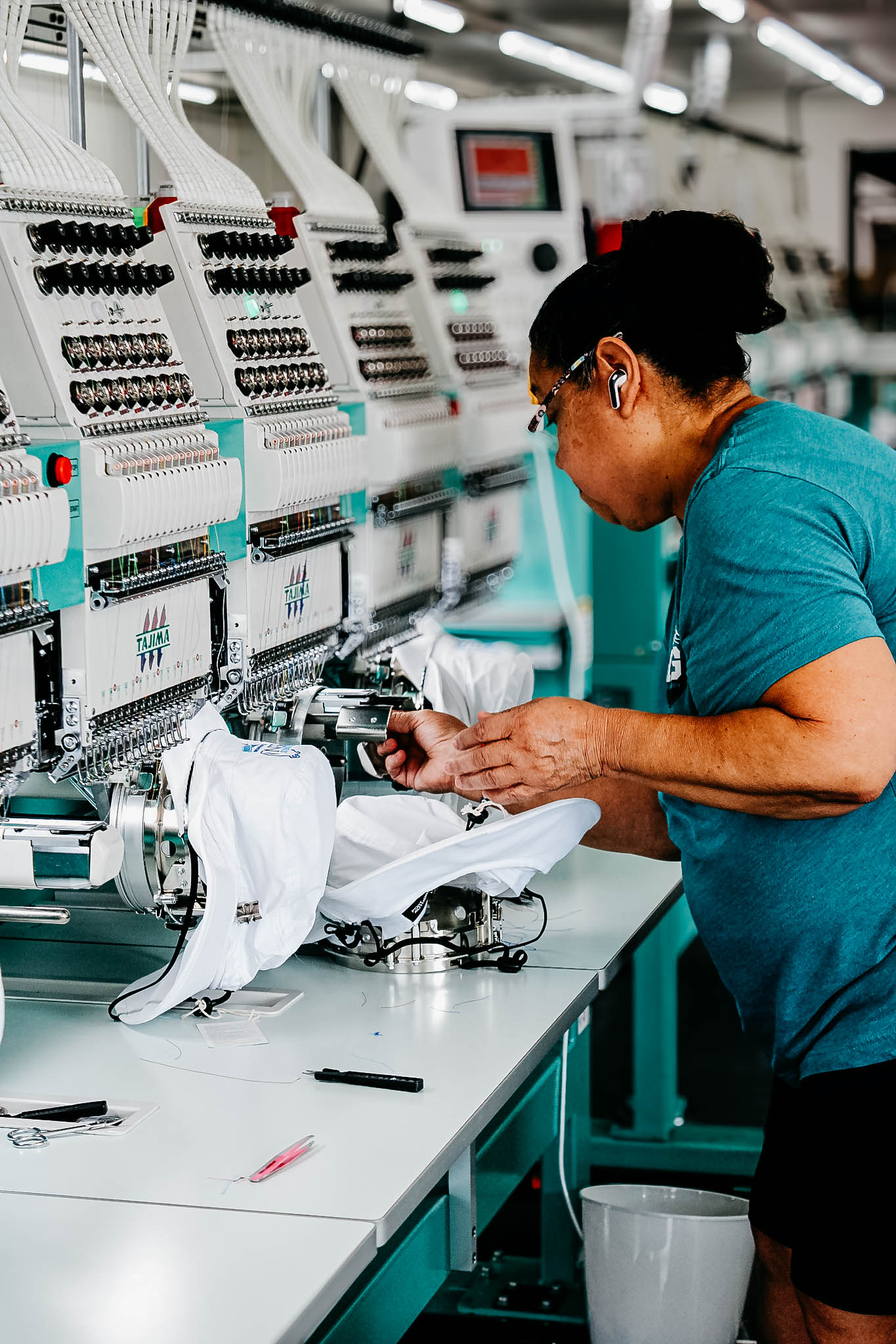 Beatrice Miranda embroidering white hats